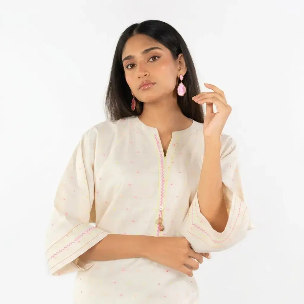 Woman wearing a white traditional outfit with pink accents on a white background